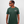 Man wearing a green t-shirt with A Greenhouse Amsterdam logo 