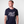 Man wearing a navy blue Green House t-shirt with white text and graphics on a plain background
