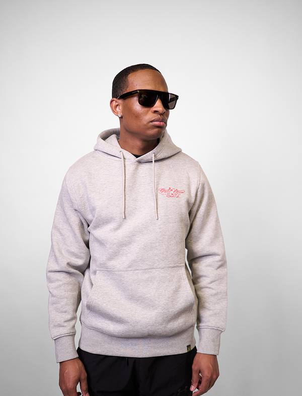 Man wearing a gray GREEN HOUSE  Fullgass hoodie with a small red logo on a plain background