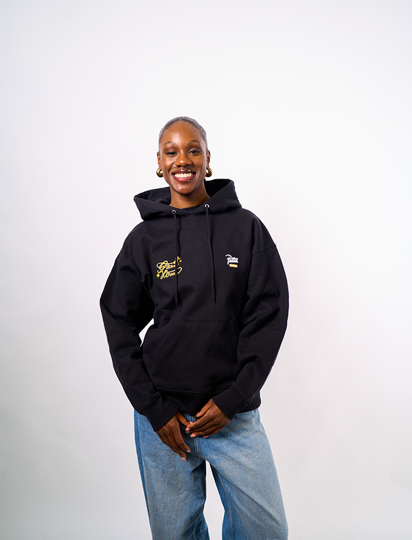 Person wearing a black Green House X Patta hoodie with logos on a white background