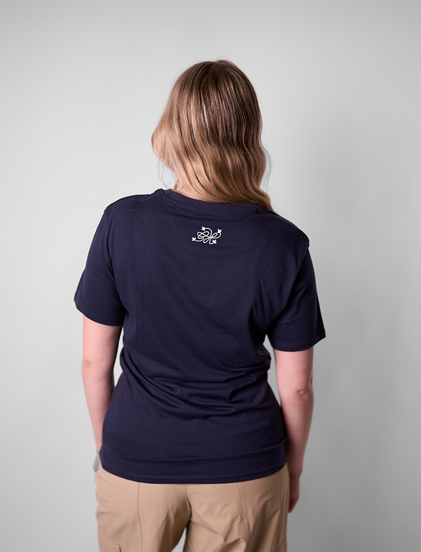 Person wearing a navy blue t-shirt with a Green House logo on the back against a plain background