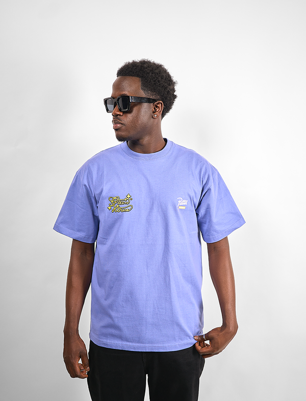 Man wearing a light purple GREENHOUSE X PATTA t-shirt 