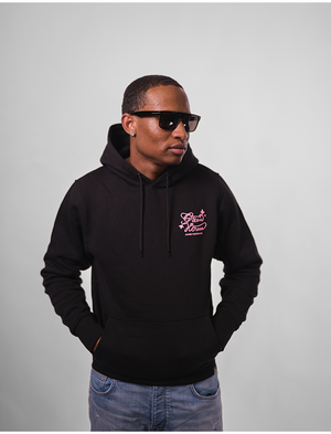 Man wearing a black GH Creators Of Champions Black Pink Hoodie
 hoodie with a logo on a gray background
