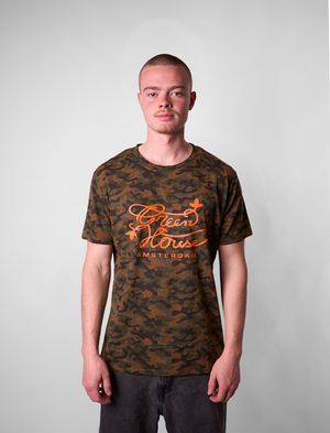 Person wearing a GH T-Shirt camouflage t-shirt with orange text on a plain background