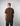 Man wearing a Green House camouflage t-shirt against a plain background