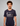 Man wearing a navy blue Green House Feeding t-shirt with a logo and text on a gray background