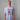Person wearing a light blue Green House Light Blue TUKTUK t-shirt with a graphic design on a gray background