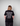 Person wearing Green House World Cities T-Shirt Black with white text on the back against a gray background